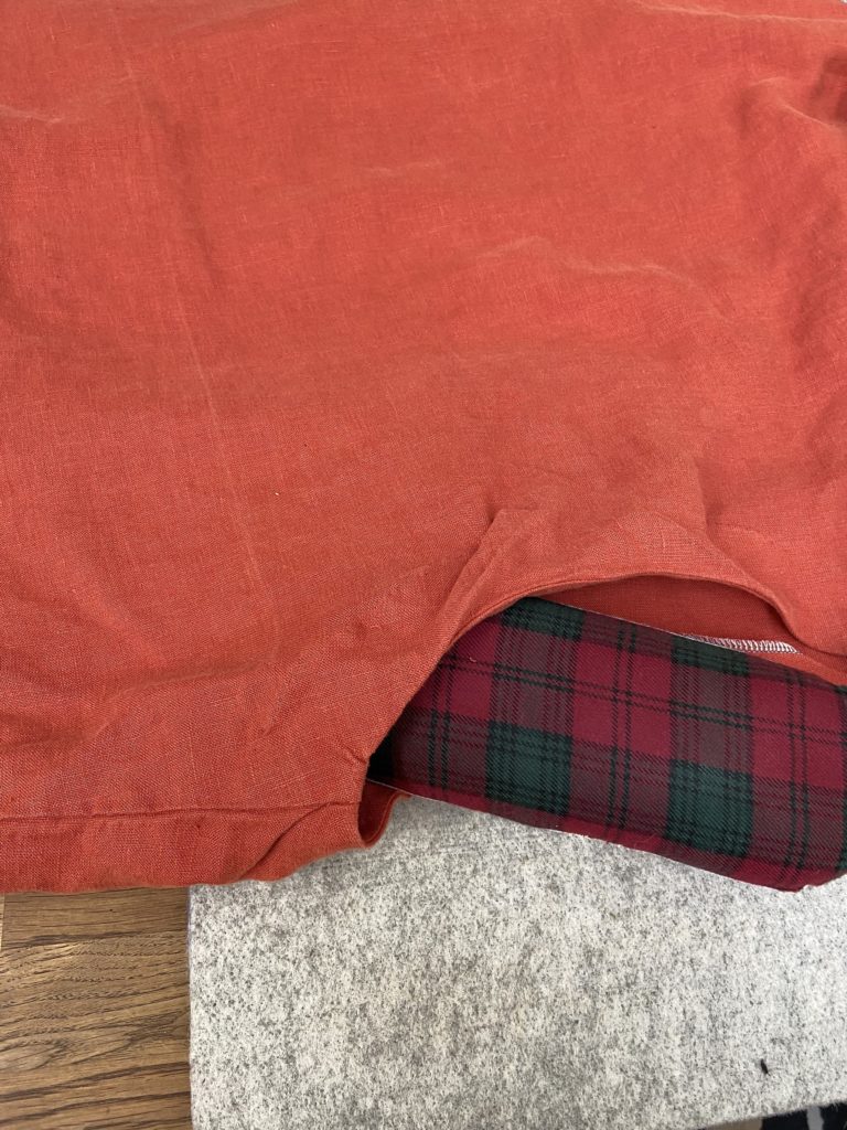 A red linen shirt with a red plaid seam roll inserted at the back neckline where the facing is wrinkled